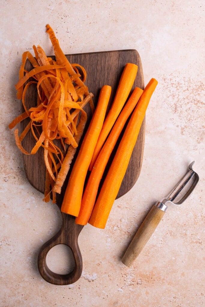 Peeled carrots on a wooden chopping board