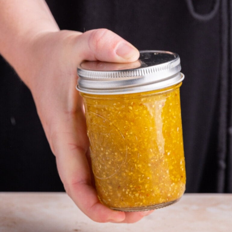 Shaking a jar with all ingredients for Maple Dijon Vinaigrette to emulsify it