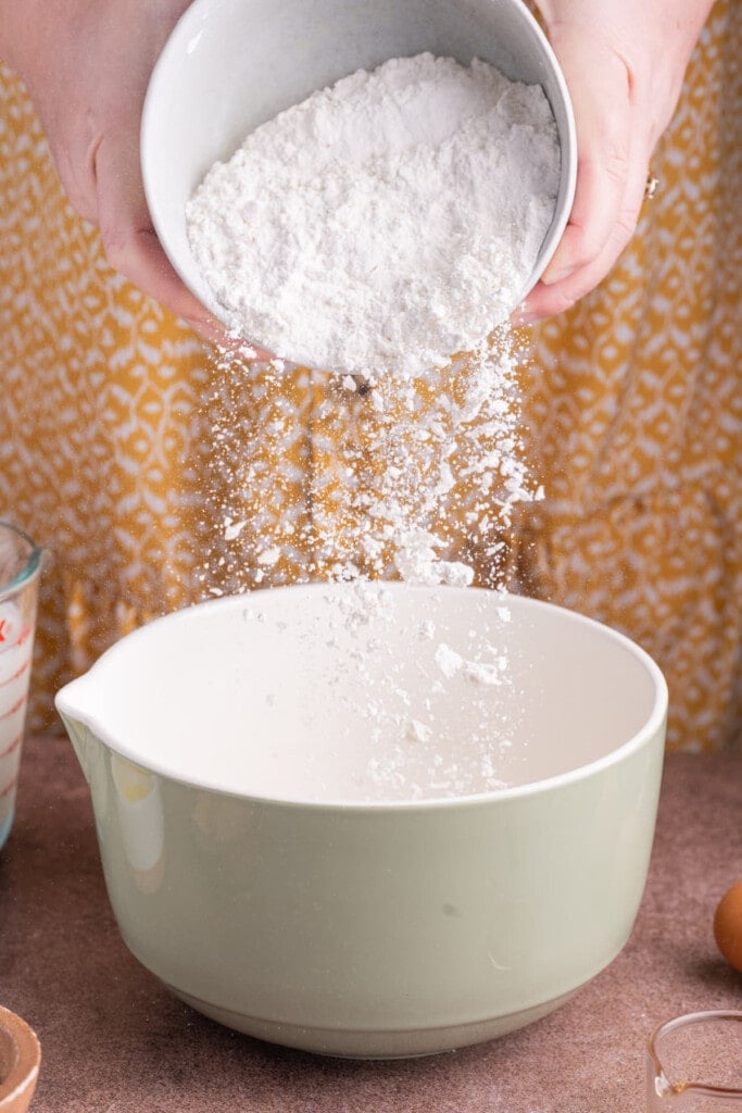 Adding flour to pancake batter.