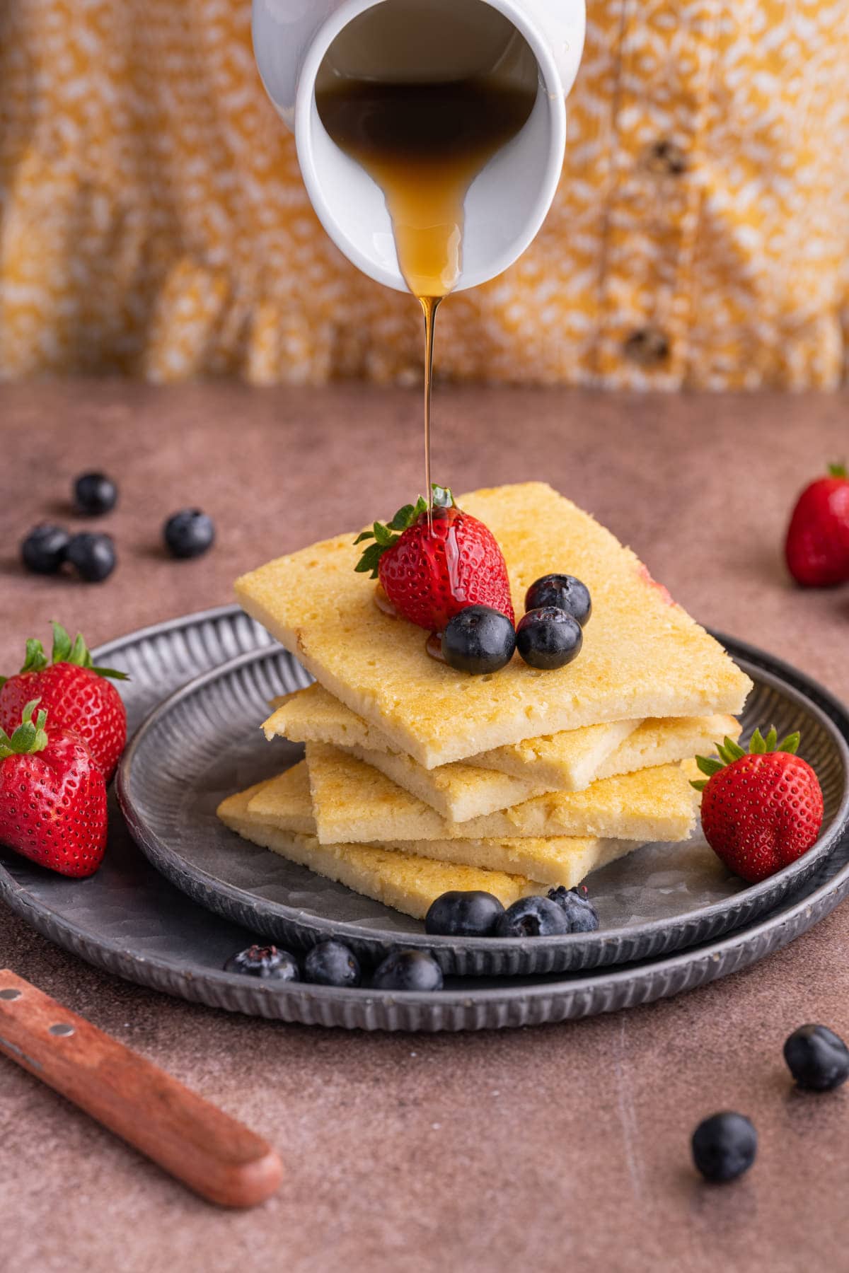 Drizzling maple syrup over oven baked pancakes