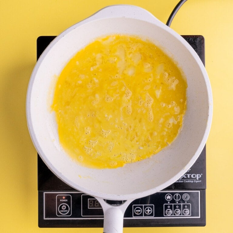 Beaten eggs heating in a pan