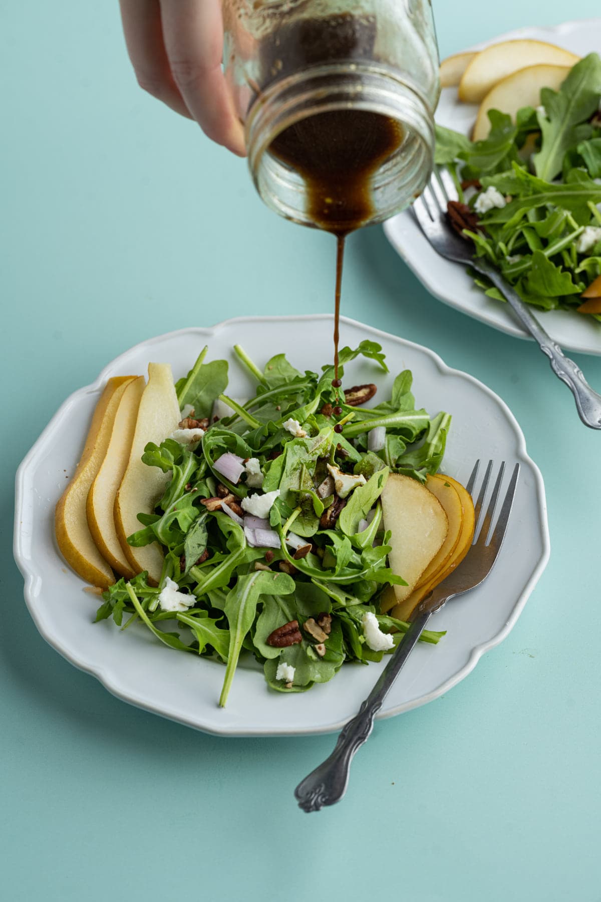 Adding oil and vinegar to Arugula Pear Salad