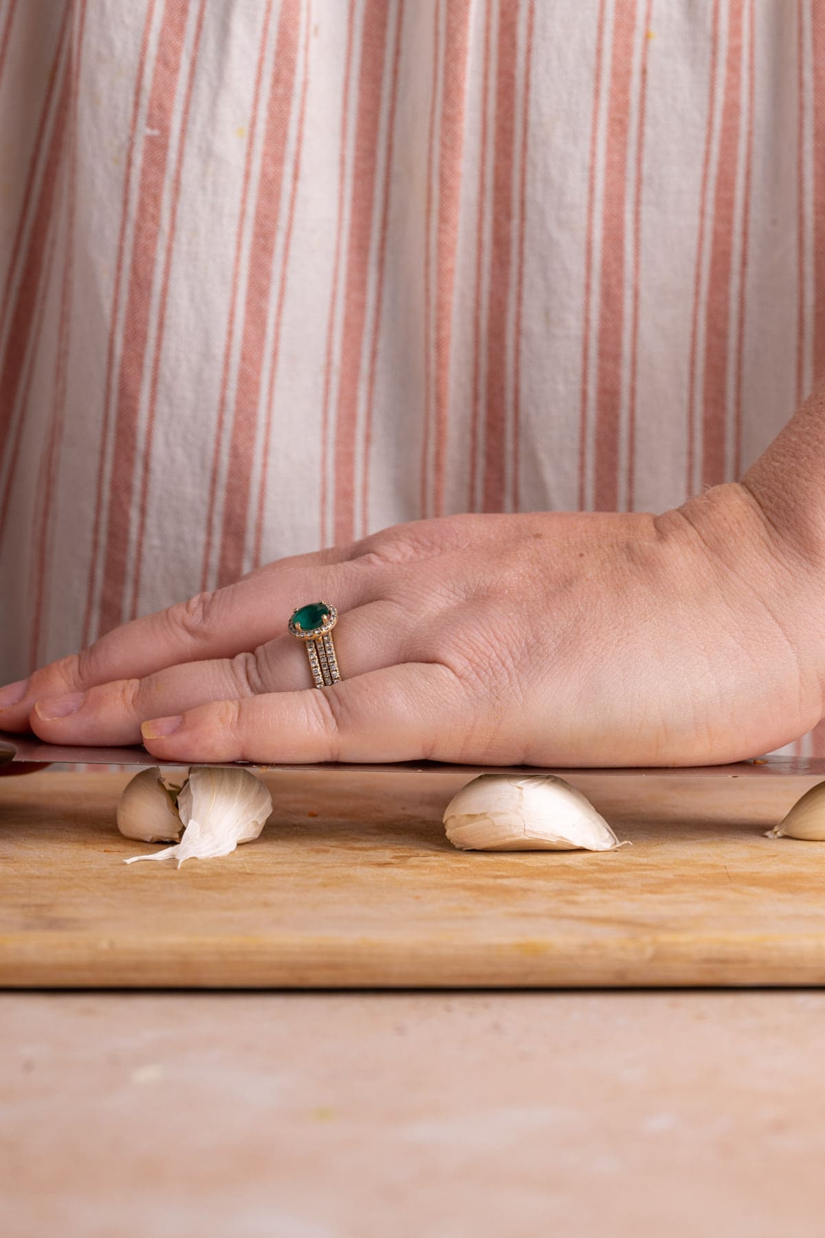 Crushing garlic flat with a knife to make it easier to peel