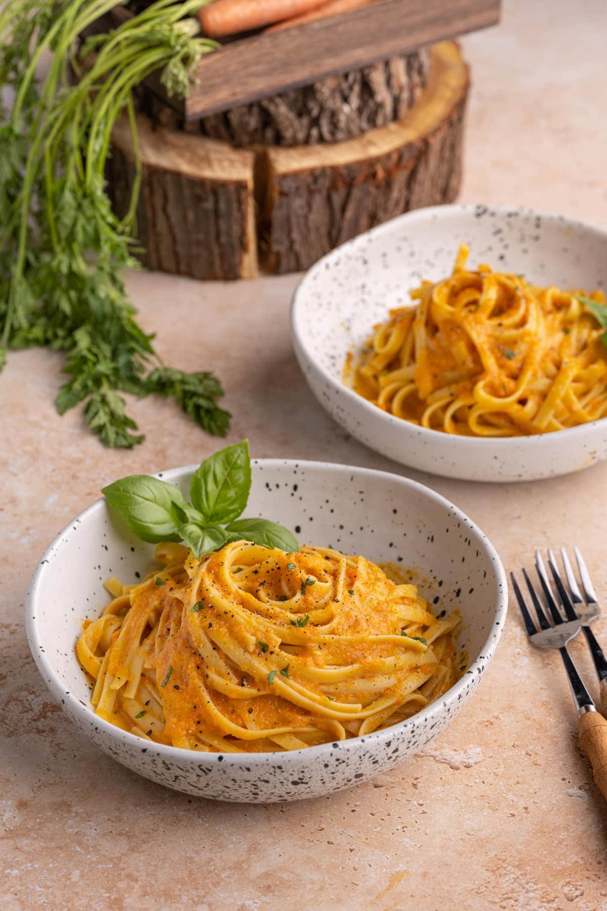 Two bowls of pasta with carrot sauce