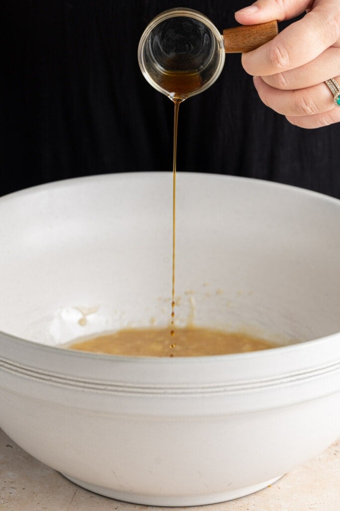 Adding vanilla extract to banana bread batter.