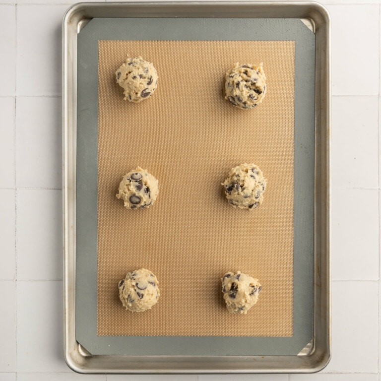 Cookies lined up on a baking sheet ready for the oven