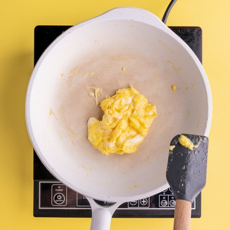 Cooking eggs in pan and bringing them to the center
