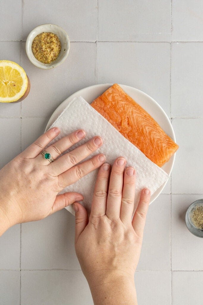 Patting salmon dry before adding marinade.