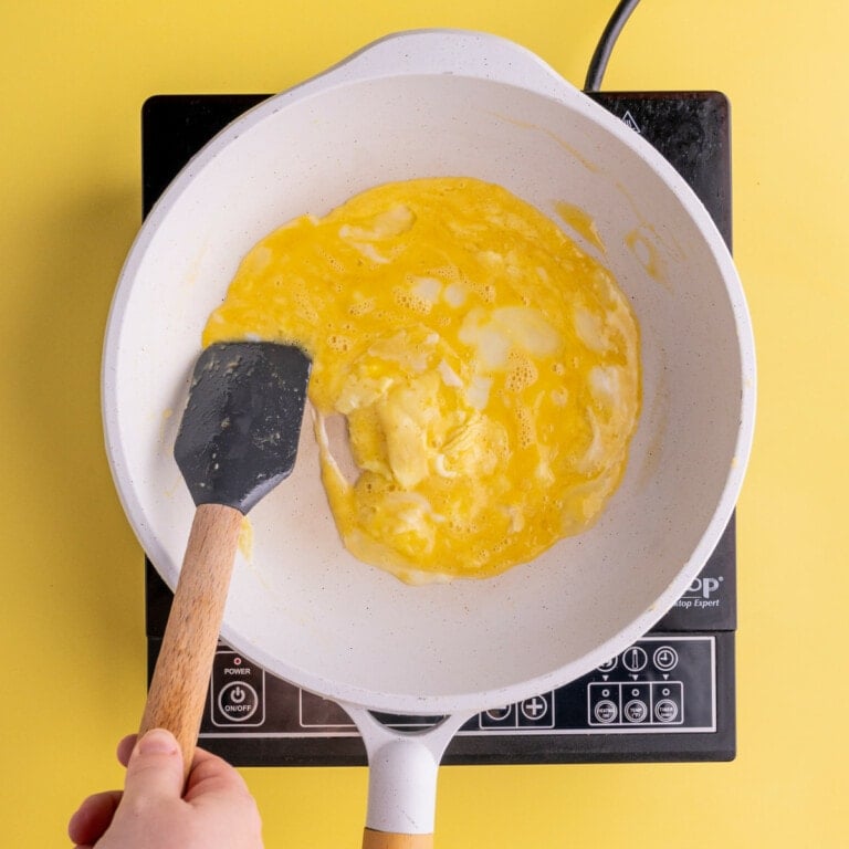 Using spatula to circle eggs