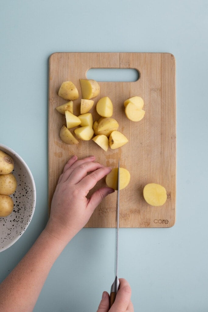 Slicing honey gold potatoes to prep for roasting.