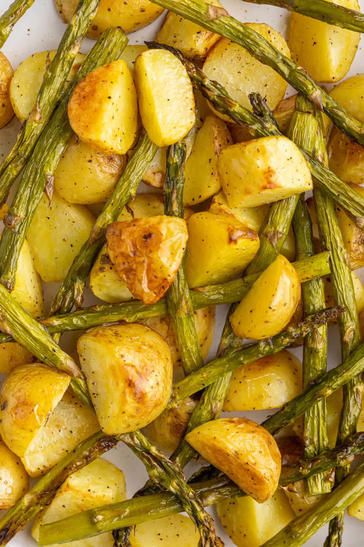 Close up of golden brown honey gold potatoes and crispy asparagus