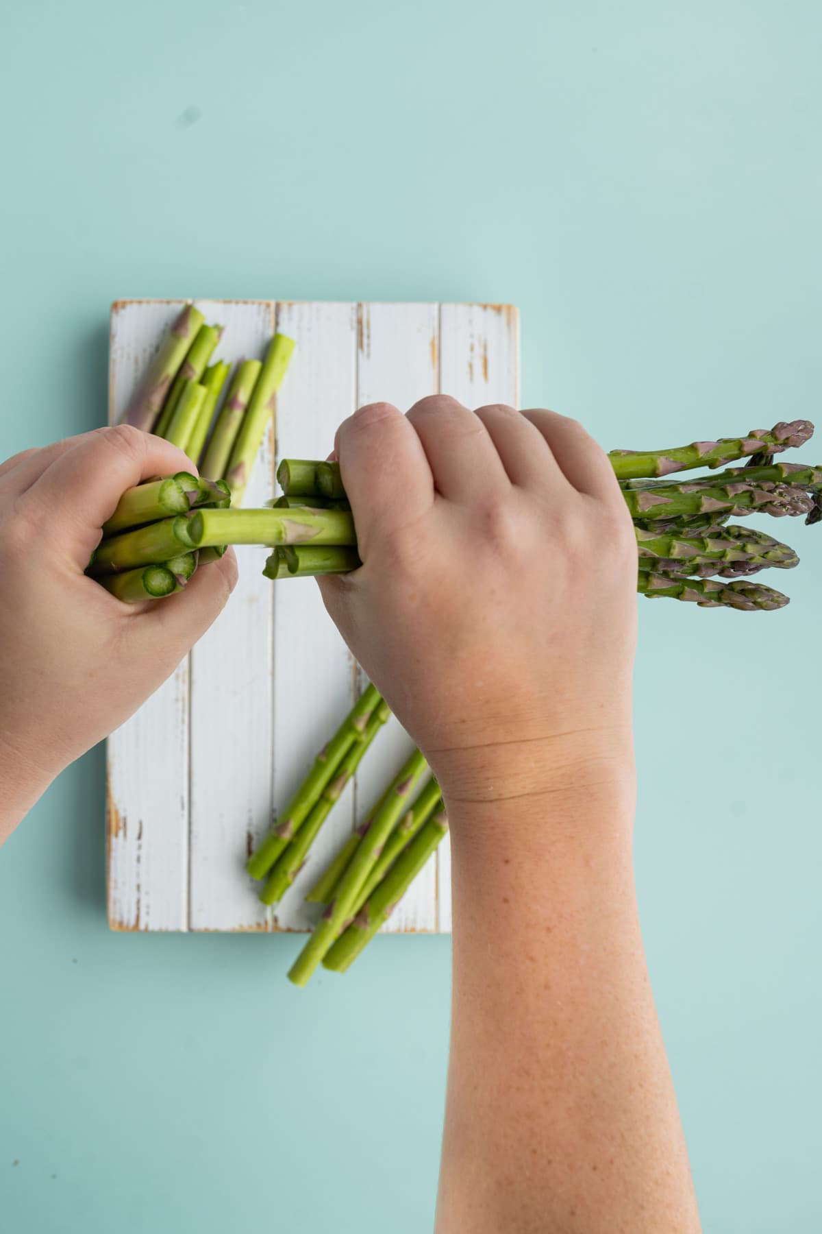 Snapping ends off of asparagus to roast with honey gold potatoes