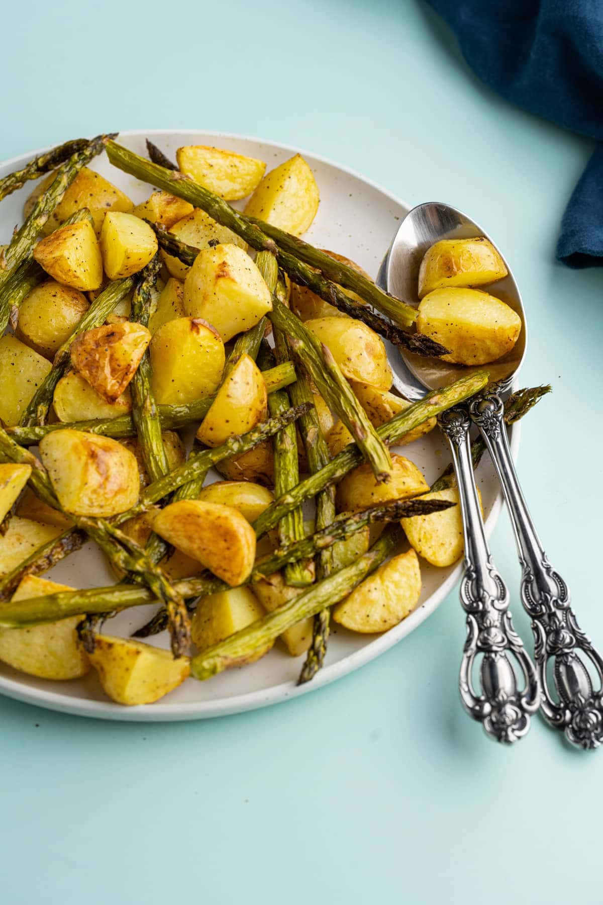 Serving platter with roasted potatoes and asparagus and serving spoons