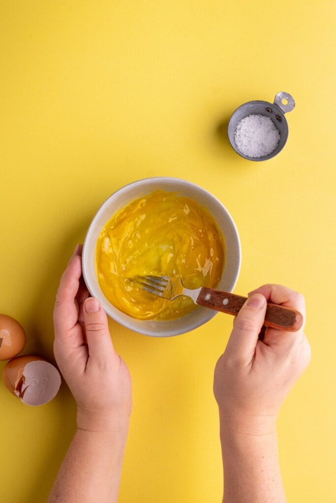Beating eggs with a fork until smooth.