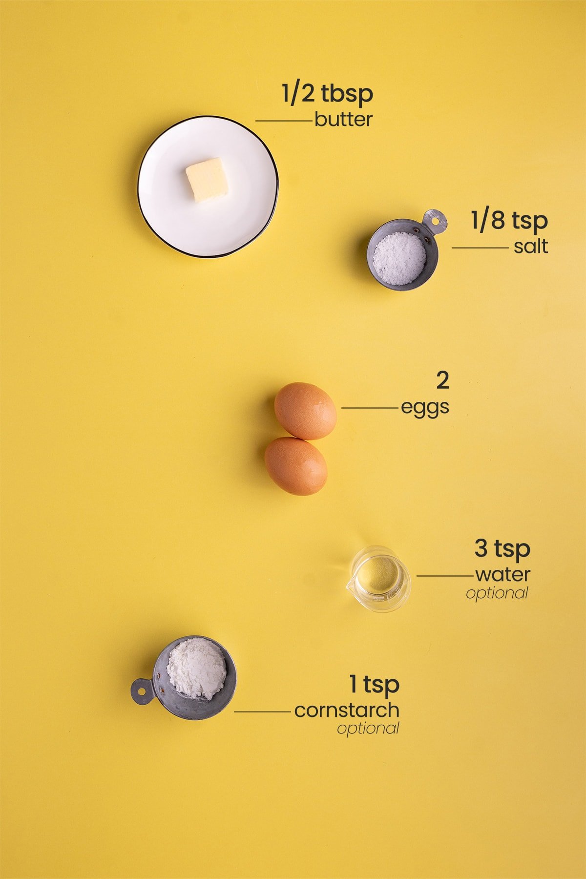 All ingredients for soft scrambled eggs including butter, salt, eggs, water (optional), and cornstarch (optional)