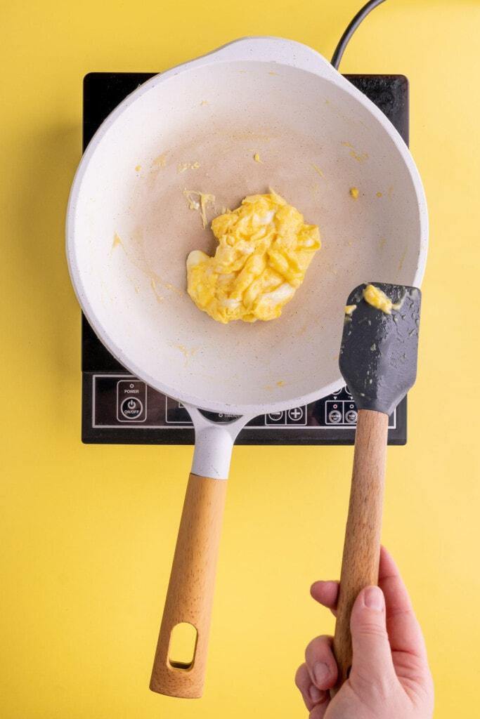 Pushing soft scrambled eggs to the center of the pan