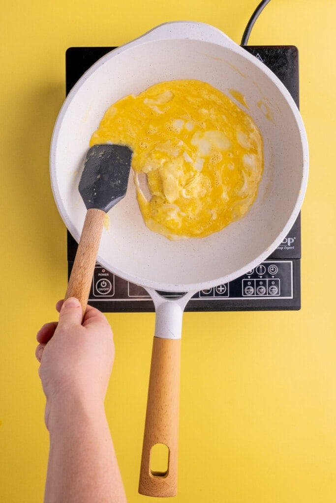 Using a spatula to scramble eggs in circular motion
