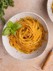 Bowl of Creamy Carrot Pasta garnished with basil