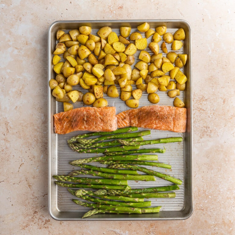 Salmon, asparagus, and potatoes ready to roast on one sheet pan