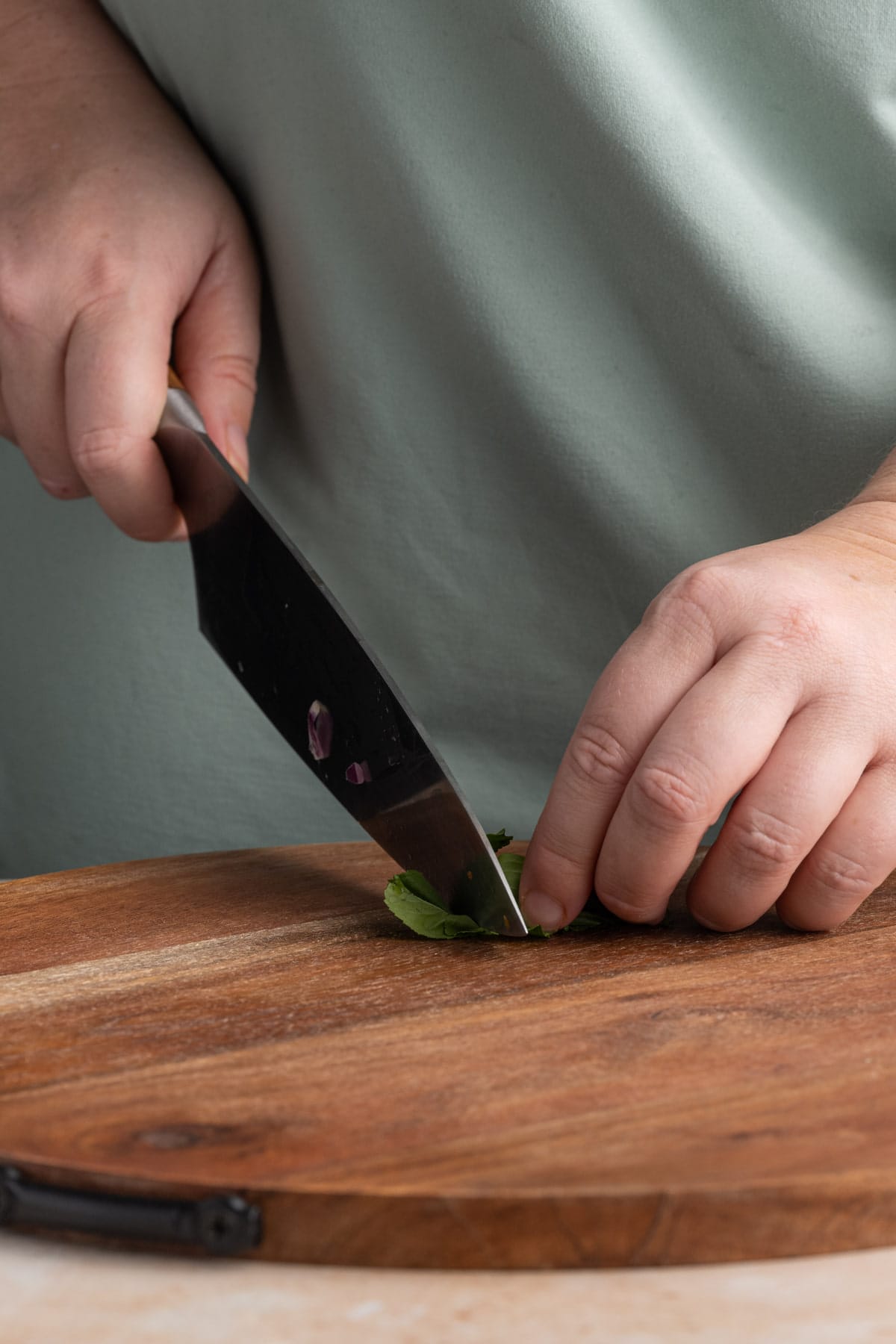 Rolling up basil to easily chop it for a Basil Balsamic Vinaigrette