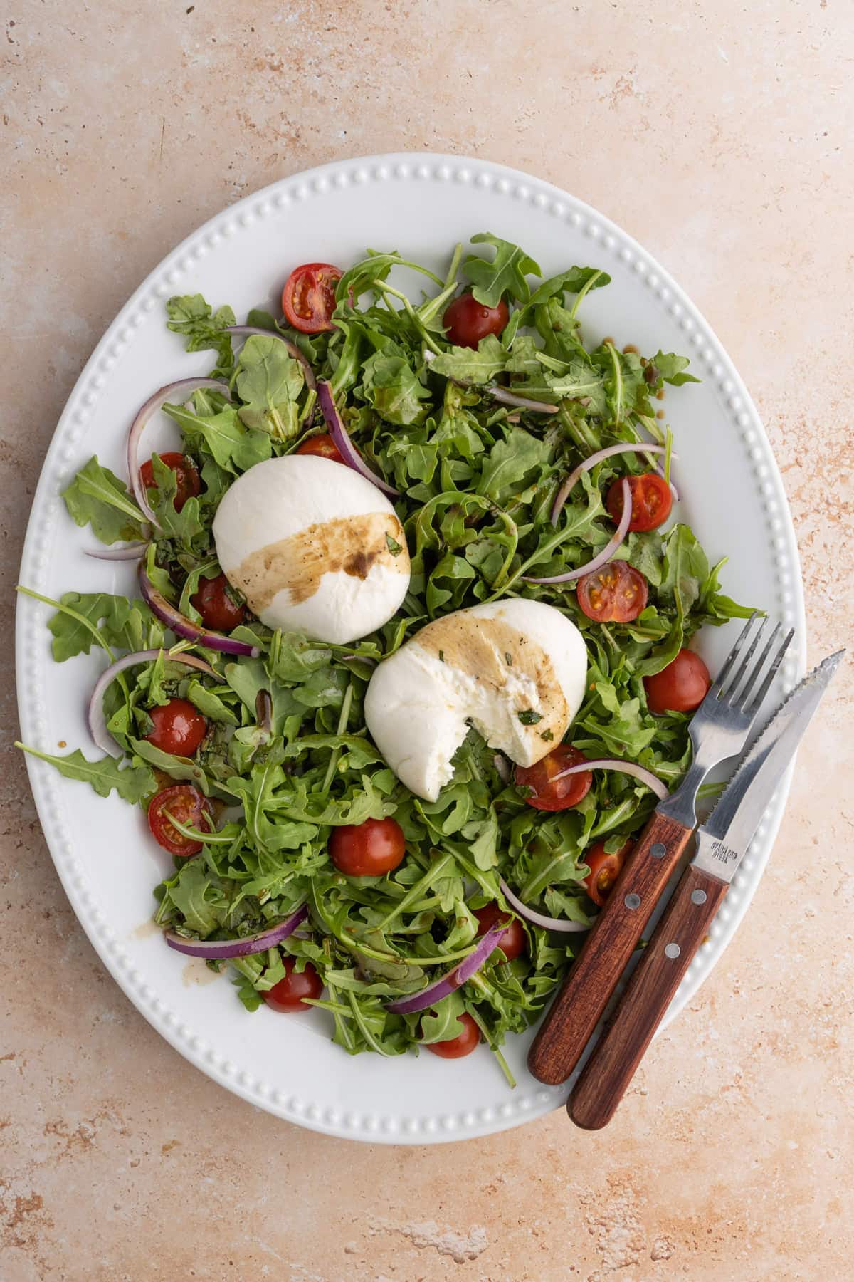 Arugula salad with burrata, grape tomatoes, red onion and a homemade Basil Balsamic Vinaigrette