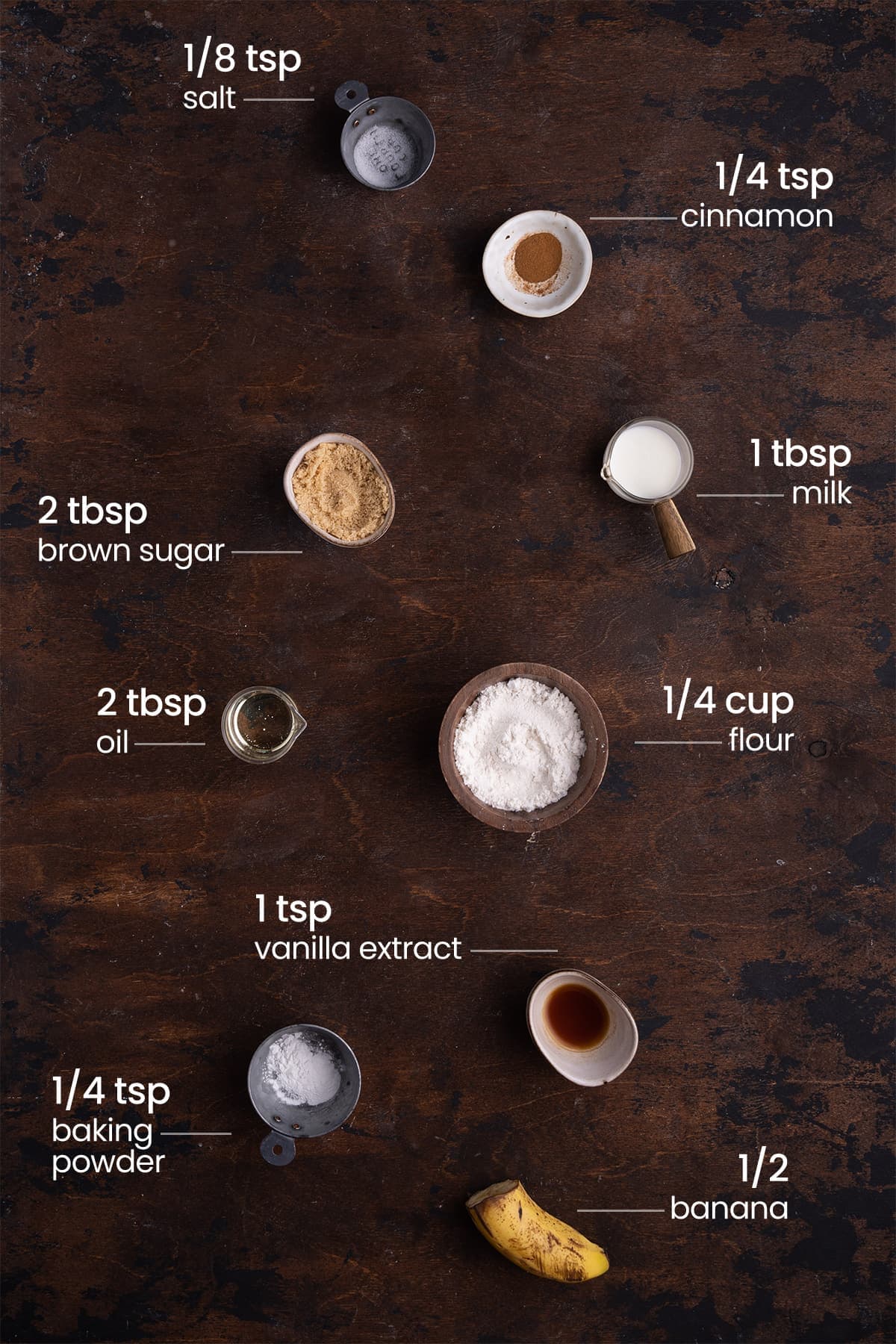 all ingredients for banana bread mug cake - salt, cinnamon, brown sugar, milk, oil, flour, vanilla extract, baking powder, banana