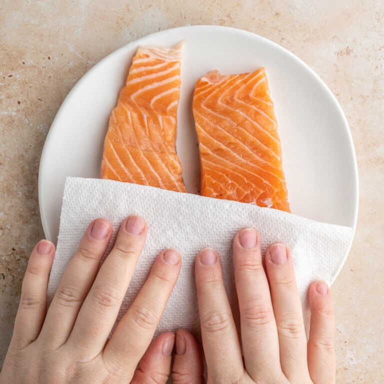 Blotting salmon dry so it has the best texture after roating it