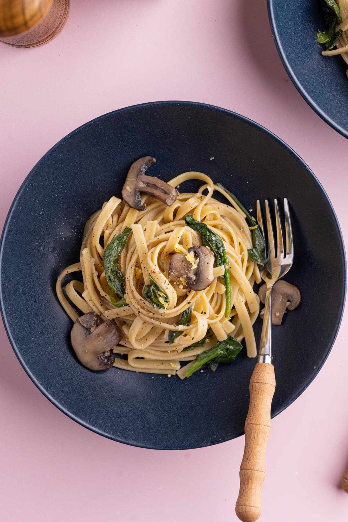 Mushroom Spinach Pasta in a shallow navy blue bowl