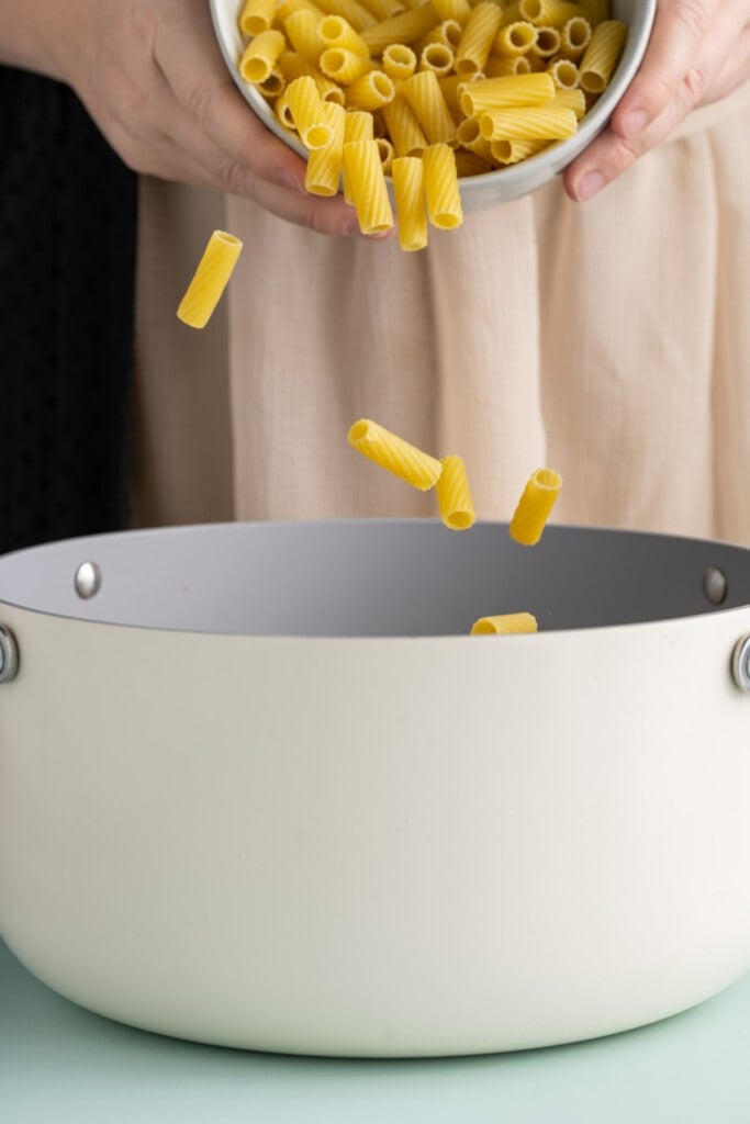 Adding pasta to boiling water to cook al dente.