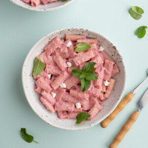 Overhead image of pink sauce pasta with beets and goat cheese