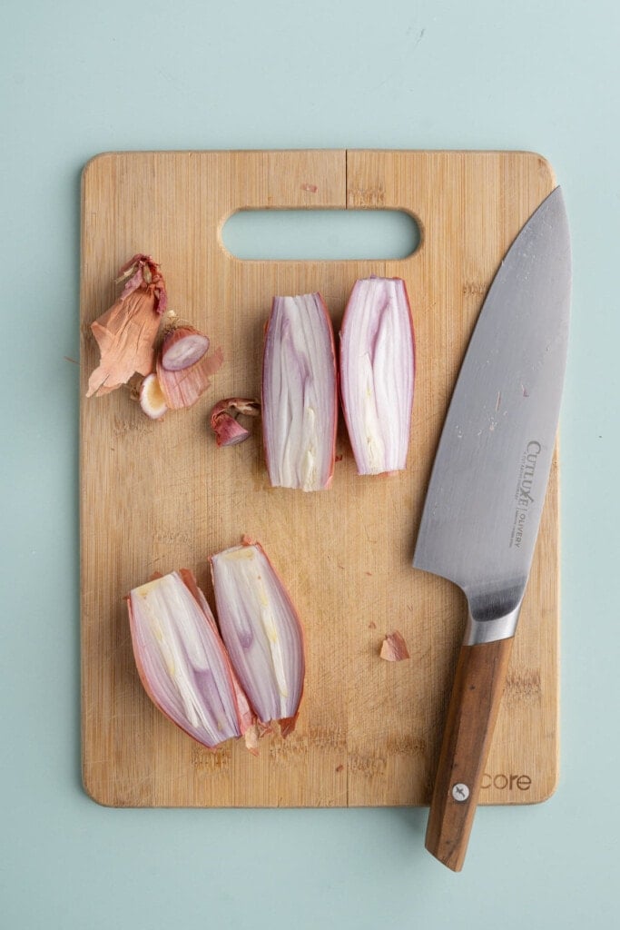 Slicing shallot in half lengthwise to make it easier to peel
