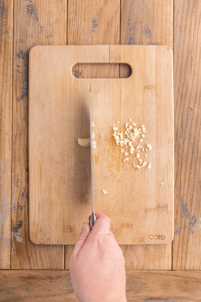 Mincing garlic to add to marinade for portobello mushrooms