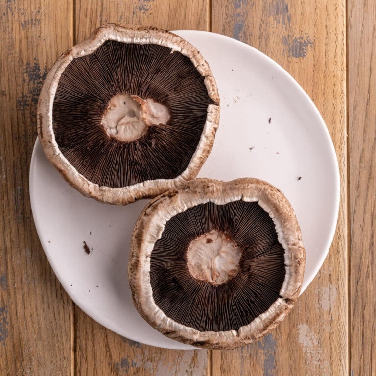 Two cleaned Portobello mushroom caps on a plate