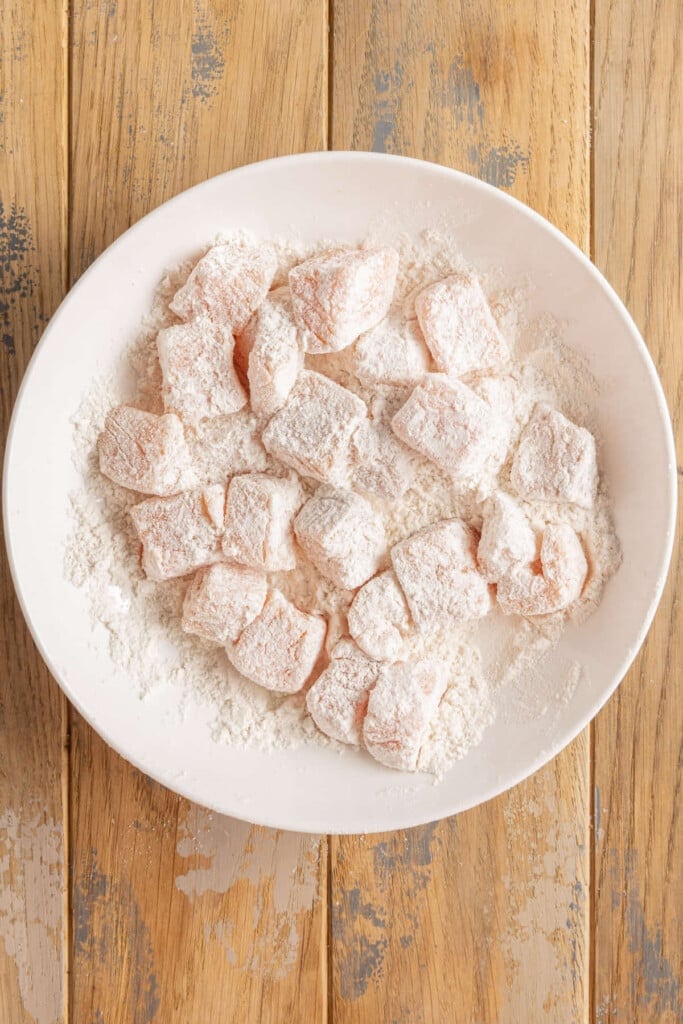 Coating cubed salmon in flour