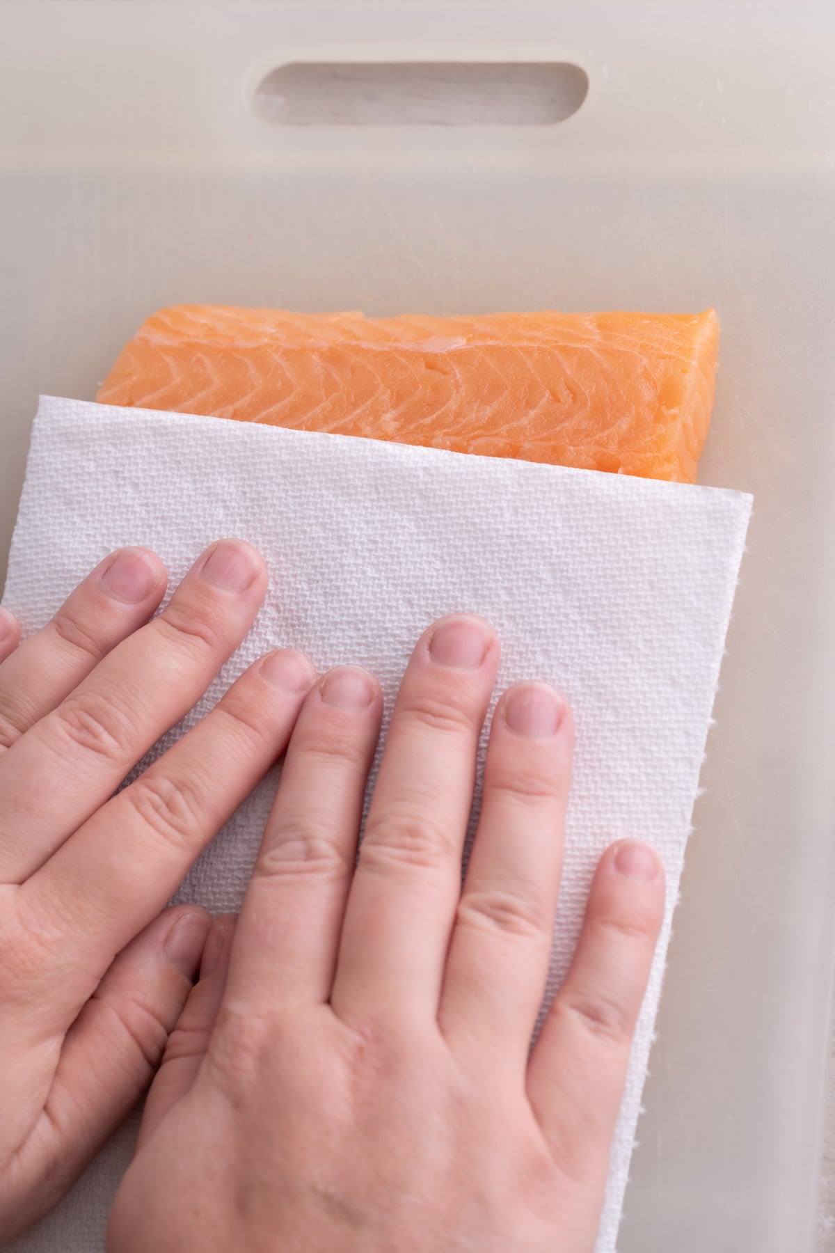 Patting dry a piece of skinless salmon