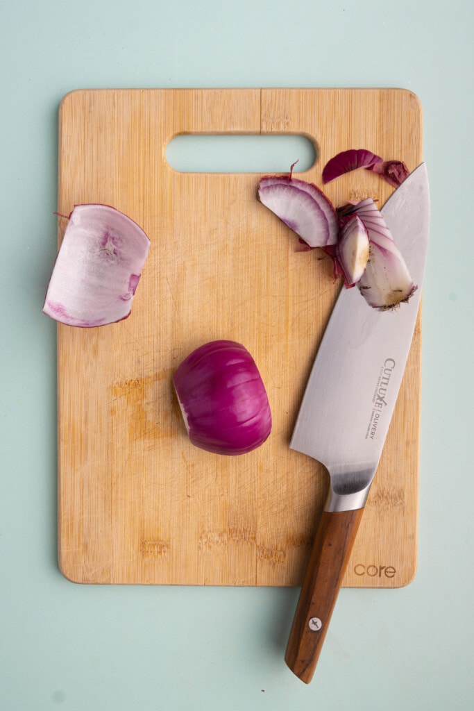 Cutting around core of red onion and peeling it