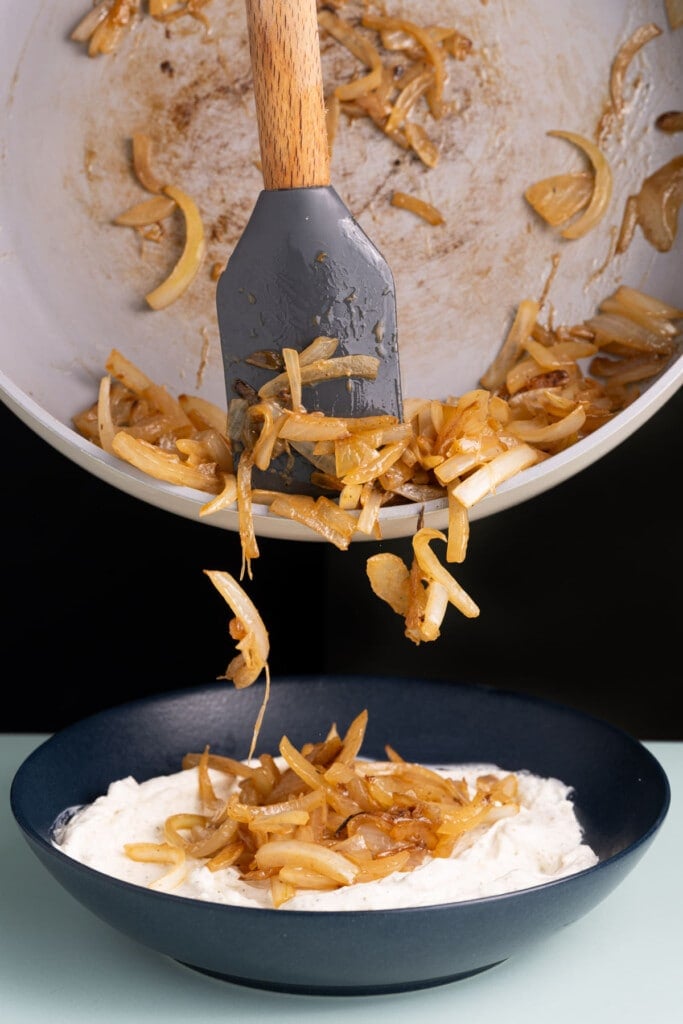 Adding caramelized onions to dip.