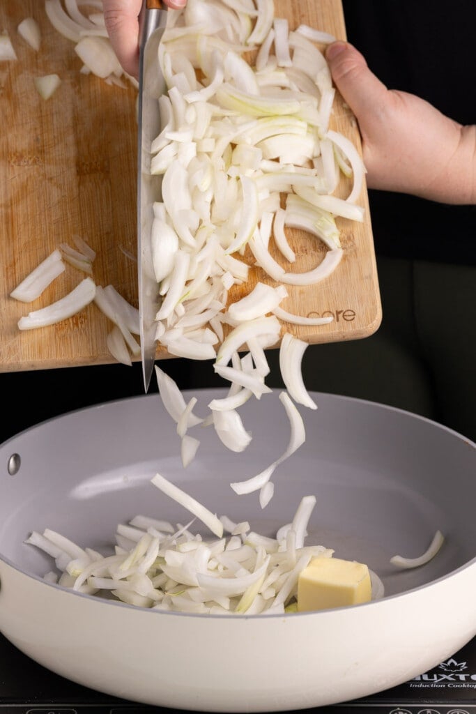 Adding onions to frying pan to caramelize.