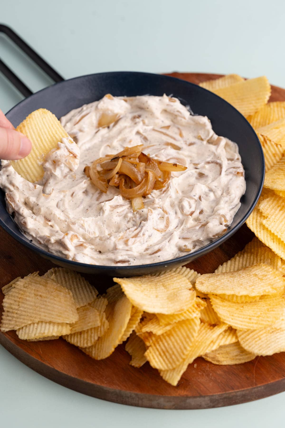 Dipping a chip into Caramelized Onion Dip
