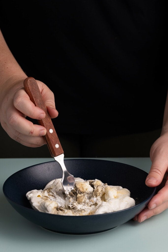 Using a fork to combine Caramelized Onion Dip.