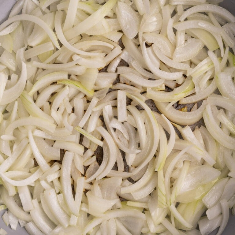 Onion sliced thin frying in heavy bottomed pan