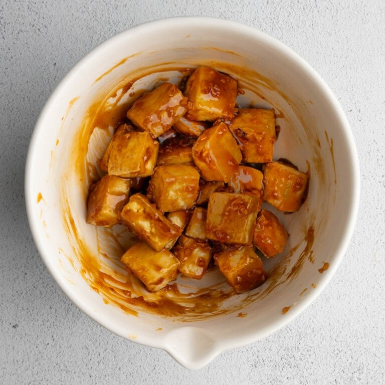 Tossing crispy baked tofu in honey and garlic sauce