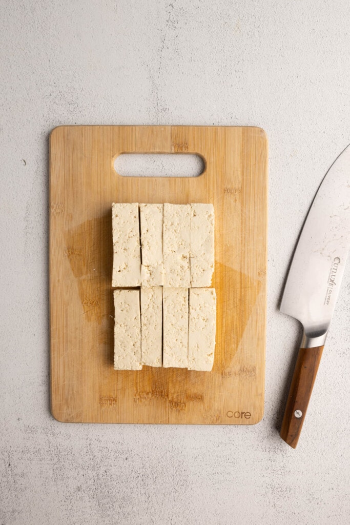 Slicing halved tofu into long strips