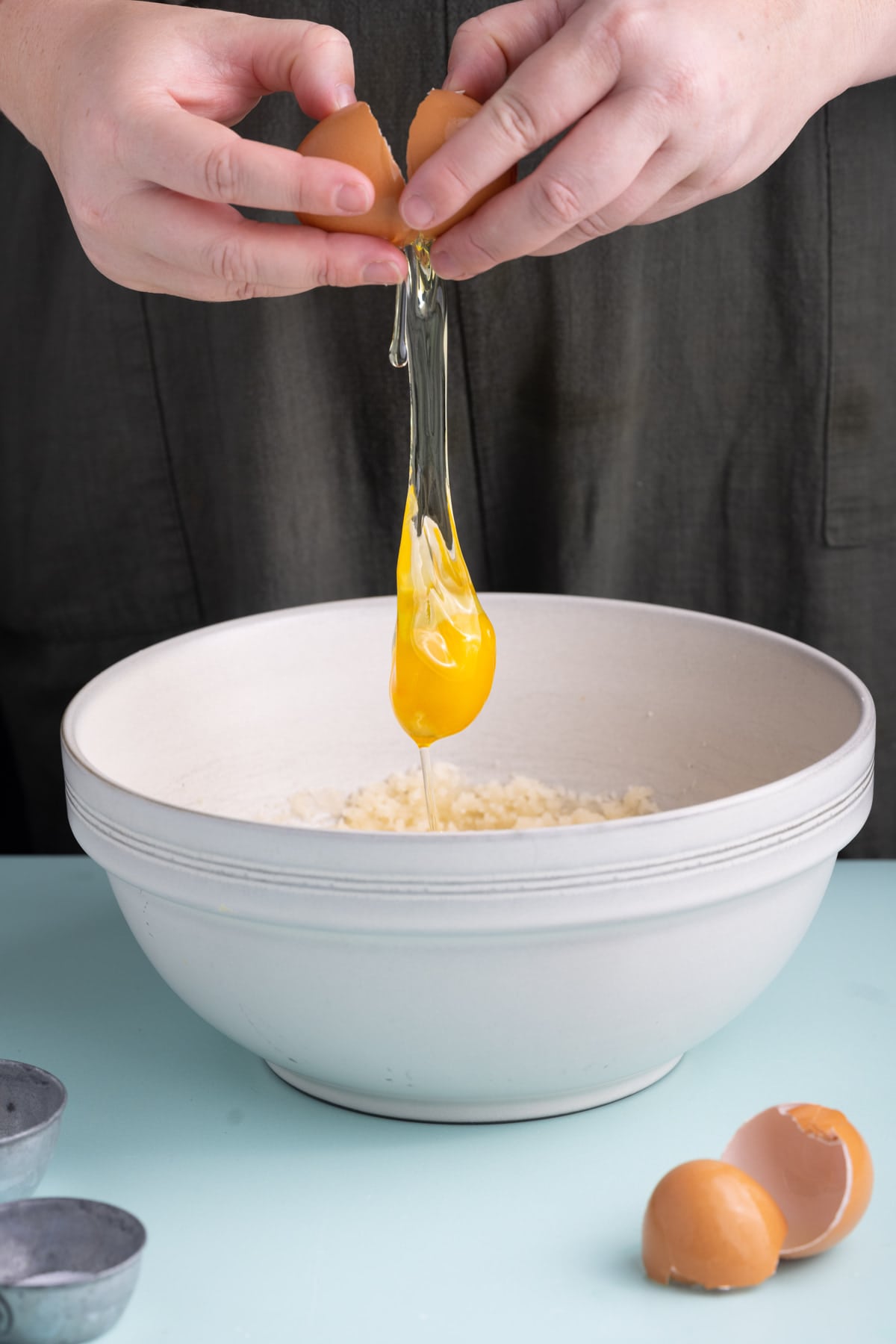 Cracking eggs into creamed oil and sugar mixture