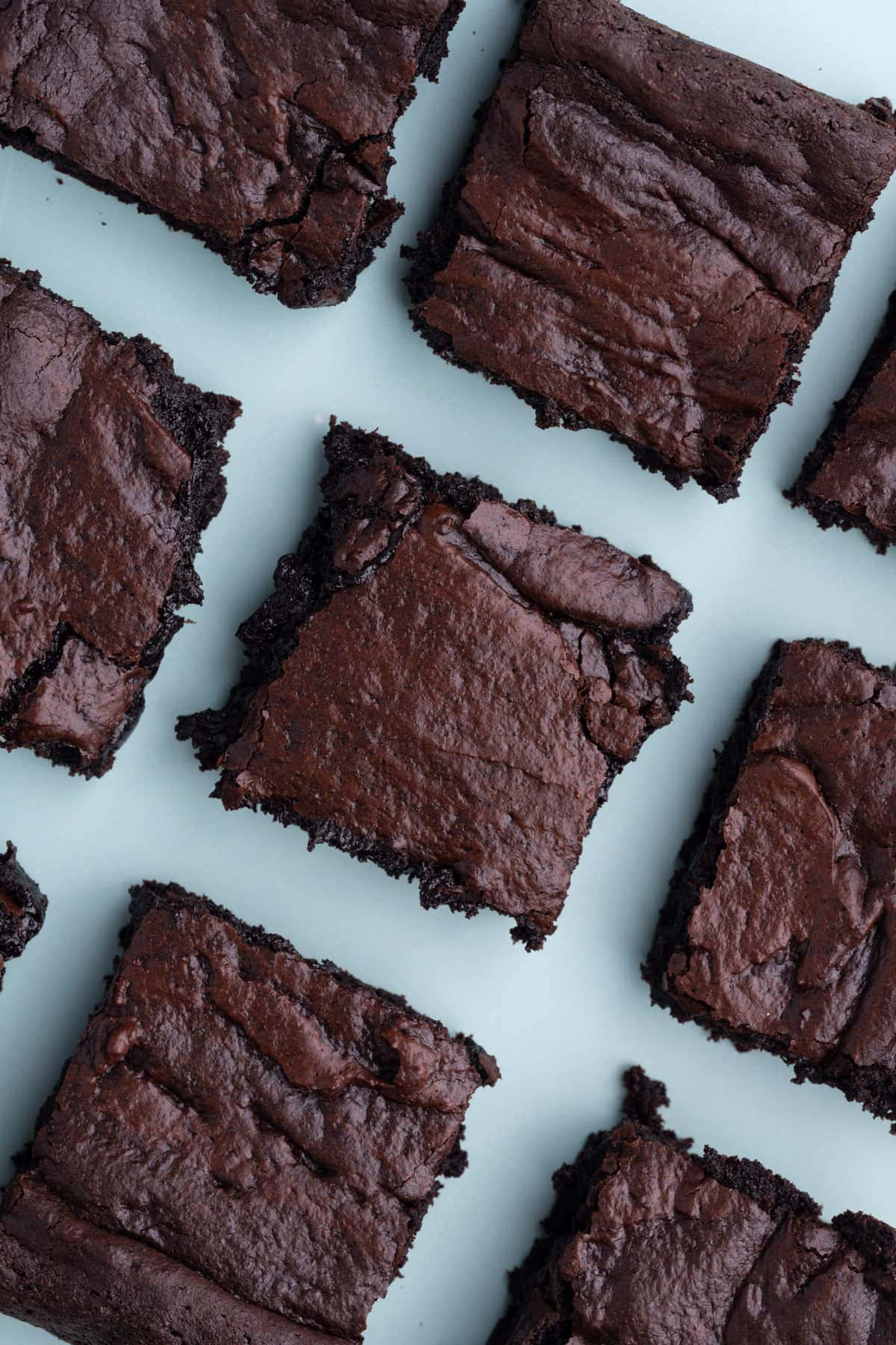 Olive Oil Brownies lined up on blue backdrop