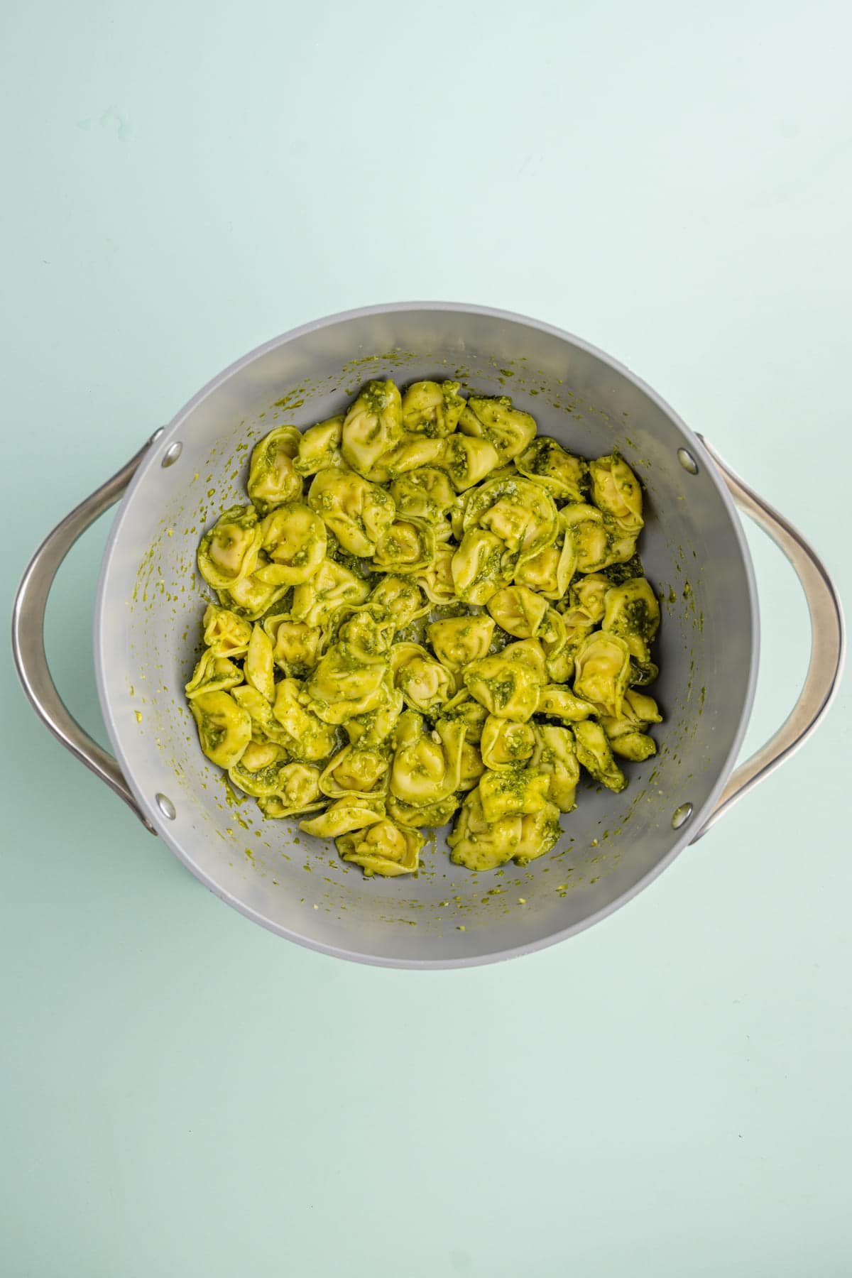Adding Pesto to pot with cooked tortellini and pasta water