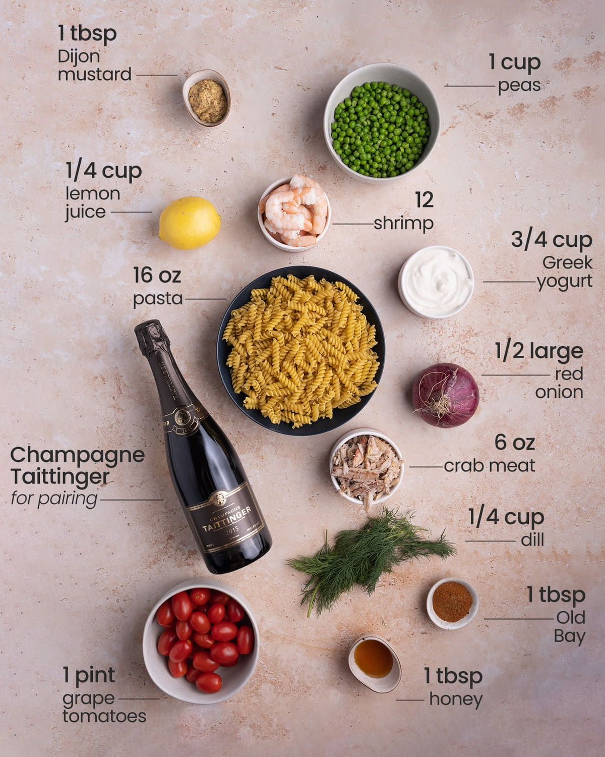 All ingredients for Seafood Pasta including Dijon mustard, green peas, cooked shrimp, lemon, short pasta, Greek Yogurt, red onion, crab meat, fresh dill, Old Bay Seasoning, honey, grape tomatoes, and Champagne Taittinger for pairing