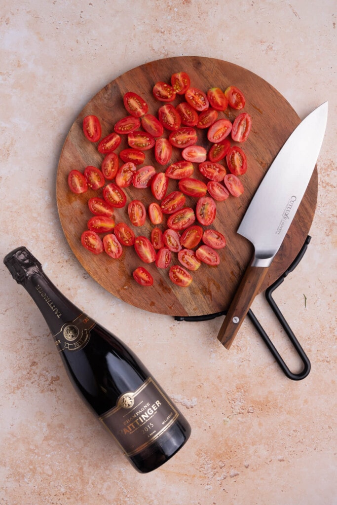 Slicing grape tomatoes in half lengthwise to add to pasta salad