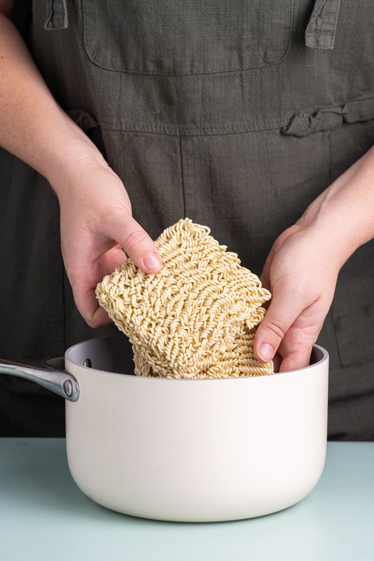 Adding ramen noodles to boiling water