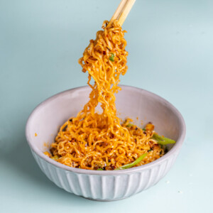 Spicy Garlic Noodles being lifted by chopsticks